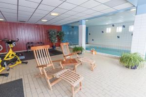 a room with two wooden chairs and a swimming pool at Hotell Bruksvallsliden in Bruksvallarna