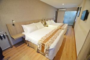 um quarto de hotel com duas camas e uma televisão em Diamond Inn em Kota Kinabalu