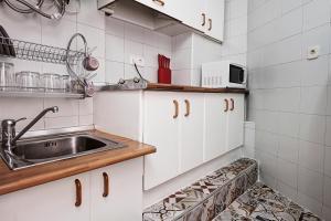 グラナダにあるVentana Del Albaycinの白いキャビネットとシンク付きのキッチン