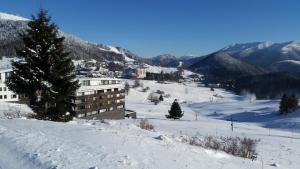 a building on a snow covered slope with a mountain at Apartman 0204 Donovaly in Donovaly