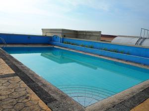 a swimming pool with blue tiles on a building at Suites de Marina Manila with Netflix in Manila