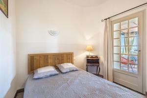a bedroom with a bed with two pillows and a window at La Maison des Roches in Gordes