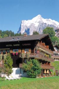 a hotel with a mountain in the background at Hotel Cabana in Grindelwald