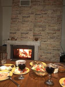 einen Tisch mit Speise- und Weingläsern und einen Kamin in der Unterkunft Apt ECE PAMPOROVO in Pamporowo