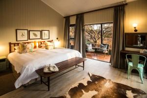 a bedroom with a large bed and a table and chairs at Three Tree Hill Lodge in Bergville