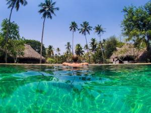 a man in the water at a resort at Marari Beach Resort Alleppey - A CGH Earth Experience in Alleppey