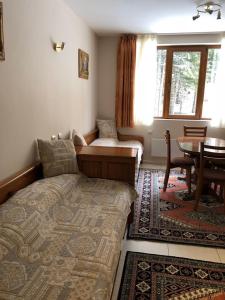 een slaapkamer met een bed en een tafel in een kamer bij Manastira 2 apt Emo Pamporovo in Pamporovo