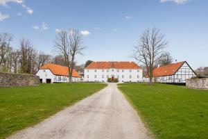 a dirt road in front of a large white building at Ny Øbjerggaard Bed and Breakfast in Lundby