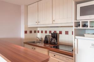 a kitchen with white cabinets and a counter top at Village Pierre & Vacances Moliets in Moliets-et-Maa