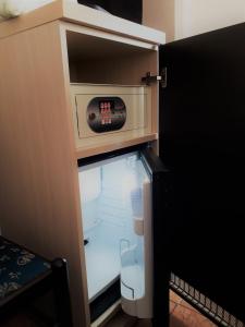 einem Kühlschrank mit offener Tür und einer Uhr darauf in der Unterkunft Hotel Sweet Home in Rom
