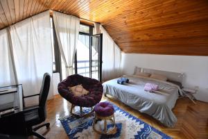 a bedroom with a bed and a chair and a television at Villa Mina Kladovo, 5-Bedroom Villa with Pool for up to 12 People in Kladovo +55 photos