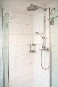 a shower in a bathroom with white tiles at Ferienunterkunft Heidi in Blieskastel