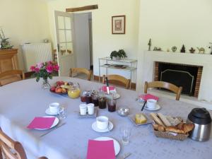 una mesa con un mantel blanco con comida. en Les Quatre Saisons, en Moitron-sur-Sarthe