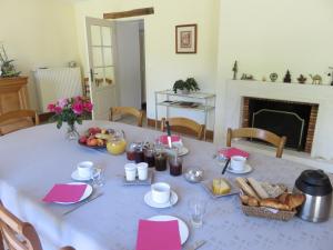 a table with a white table cloth with food on it at Les Quatre Saisons in Moitron-sur-Sarthe