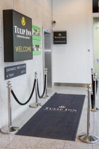 a black welcome mat in front of a building at Tulip Inn Eindhoven Airport in Eindhoven