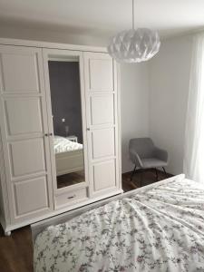 a bedroom with a large white cabinet with a mirror at Rudis in Monschau