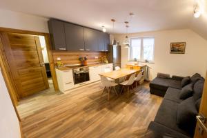 a kitchen and living room with a table and a couch at Apartments Laznica in Cerkno +17 photos