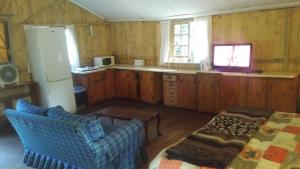 a kitchen with wooden cabinets and a couch and a table at Isikhoma-Khoma in Hilton