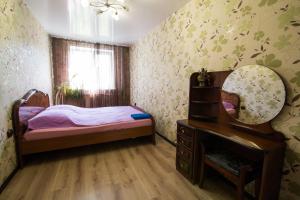 a small bedroom with a bed and a mirror at Apartments on Kirova 76 in Novokuznetsk