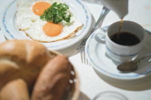 uma mesa com um prato de ovos e uma chávena de café em Hotel Gasthof Schöpf em Längenfeld
