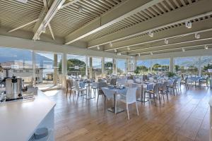 een eetkamer met tafels, stoelen en ramen bij Hotel Vischi in Domaso