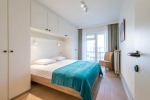 a bedroom with a bed with a blue blanket on it at Yellow in Knokke-Heist