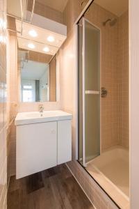 a bathroom with a white sink and a shower at Yellow in Knokke-Heist