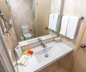 a bathroom with a sink and a toilet and a mirror at Hotel Aqua in Marmaris