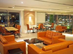 a restaurant with orange furniture and tables and chairs at Gold Orchid Bangkok Hotel in Bangkok
