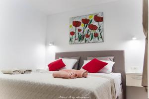 斯普利特的住宿－S&S SPLIT APARTMENT，一间卧室配有两张带红色枕头的床和绘画