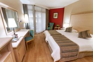 a hotel room with a large bed and two chairs at Hotel Aqua in Marmaris