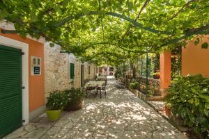 an alley with tables and chairs under a tree at Country House Apartments in Pula