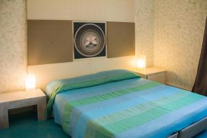 アンツィオにあるAlbergo Villa Annaのベッドルーム1室(ベッド1台、テーブル2台、写真付)