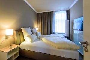 a hotel room with a large bed and a television at Ferienwohnung im Wasserwinkel in Quedlinburg