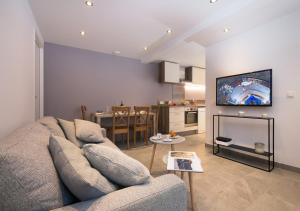 sala de estar con sofá y TV en Appartement Le Génépi - Happy Rentals, en Chamonix-Mont-Blanc