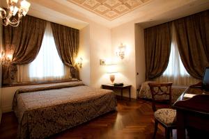 a hotel room with two beds and a chair at Hotel Aventino in Rome