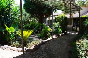 a patio with a pergola in a garden at Crystal Rose Lodge & Spa in Krugersdorp