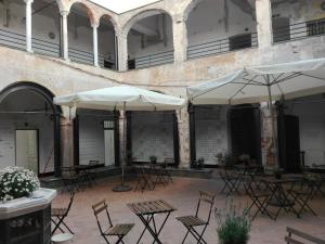 an outdoor patio with tables and chairs and umbrellas at Al Chiostro Guesthouse in Genoa