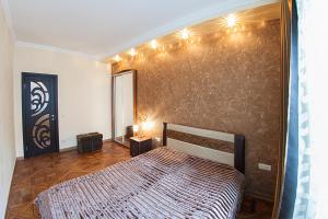 a bedroom with a bed and a wall with lights at Rynok Square - the heart of Lviv in Lviv