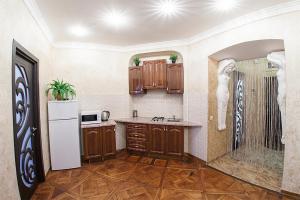 a kitchen with wooden cabinets and a white refrigerator at Rynok Square - the heart of Lviv in Lviv