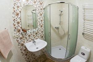 a bathroom with a sink and a shower and a toilet at Rynok Square - the heart of Lviv in Lviv +2 photos