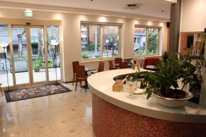a lobby with a bar with chairs and tables and windows at Hotel Ardesia in Rimini