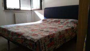 ペーザロにあるAntonioのベッドルームに掛け布団付きのベッド1台