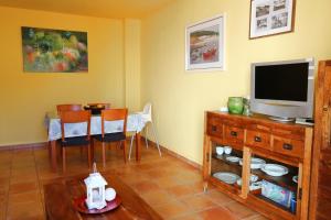 a living room with a television and a table with chairs at Apartament Antic Plankton - Calella Palafrugell - Free Parking, Beach, Wifi, Perfect holidays in Calella de Palafrugell