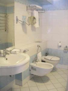 a white bathroom with a sink and a toilet at Hotel European in Dnipro