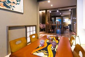 a dining room with a wooden table with yellow chairs at Kyo-machiya Flower Inn Hanayo in Kyoto