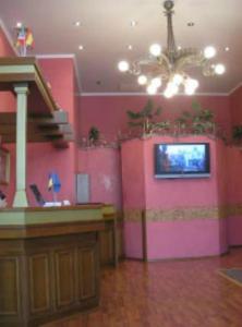 a room with a pink wall with a tv in it at Hotel European in Dnipro