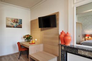 een kamer met een tafel, een tv en een open haard bij Hotel Royal Astrid in Aalst
