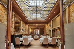 una sala da pranzo con tavoli, sedie e soffitto in vetro di Hotel Royal Astrid a Aalst