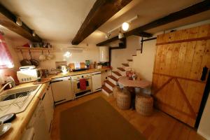 a kitchen with a wooden door and a kitchen with a stove at Conacul Copilăriei in Ruginoasa